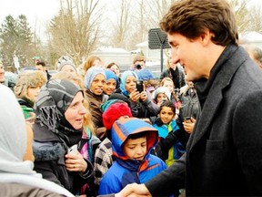 Prime Minister Justin Trudeau greets refugees in Peterborough, Ont., on Jan. 17. His government has announced an increase in the refugee and familiy reunification targets for this year, but a small increase in the target for economic migrants, such as skilled workers.