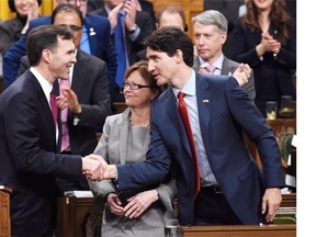 Prime Minister Justin Trudeau, right, shakes hands with Minister of Finance Bill Morneau following his federal budget speech in the House of Commons on Parliament Hill in Ottawa on Tuesday.