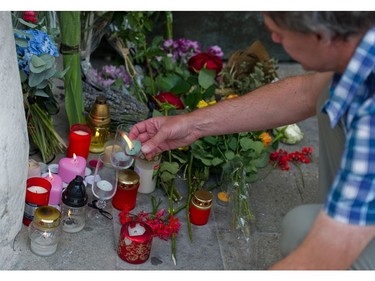 A man lights a candle near flowers placed in front of the French embassy in Bratislava on July 15, 2016, to commemorate the victims of the deadly attacks in Nice. A man drove a truck into a crowd watching fireworks in the French Riviera city of Nice, killing at least 84 people.