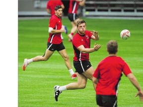 Adam Zaruba, centre, practises at B.C. Place Stadium Tuesday. He is Canada's heaviest rugby sevens player at 265 pounds.