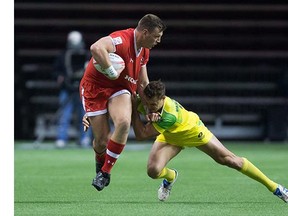 Canada's Adam Zaruba, left, fights off Australia's Stephan van der Walt during World Rugby Sevens Series' Canada Sevens tournament action, in Vancouver, B.C., on Saturday, March 12, 2016. THE CANADIAN PRESS/Darryl Dyck