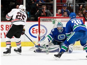 Ryan Miller #30 of the Vancouver Canucks makes a save on Dale Weise #25 of the Chicago Blackhawks in front of Jannik Hansen #36 of the Canucks during their NHL game at Rogers Arena March 27, 2016 in Vancouver, British Columbia, Canada. Chicago won 3-2. (Photo by Jeff Vinnick/NHLI via Getty Images)