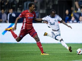 Vancouver Whitecaps' Nicolas Mezquida, top, jumps on top of his teammates as they celebrate Jordan Harvey's goal against FC Dallas.