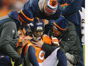 Strong safety David Bruton #30 of the Denver Broncos is attended to by trainers after a play that would force him out of the game with a reported concussion during a game against the Oakland Raiders at Sports Authority Field at Mile High on December 28, 2014 in Denver, Colorado.