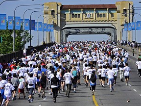 File: Runners and walkers climb the hill up the Burrard Street Bridge as they make their way through the streets of Vancouver in the Vancouver Sun Run.