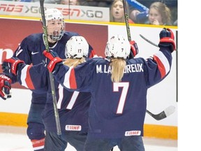 Team USA’s Hilary Knight, left, celebrates with teammates Jocelyne Lamoureux- Davidson (17) and Monique Lamoureux (7) after scoring their first goal against Canada during third period action at the women’s world hockey championships Monday, March 28, 2016 in Kamloops, B.C. Team USA won the game 3-1.
