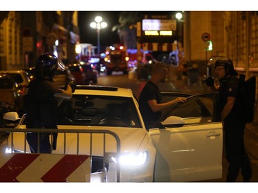 Police officers carry out checks on vehicles in the centre of French Riviera town of Nice, after a van drove into a crowd watching a fireworks display on July 14, 2016. At least 60 people are feared dead after a van drove into a crowd watching Bastille Day fireworks in the French resort of Nice on July 14, authorities said on July 15.