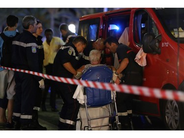 Rescue workers help an injured woman to get in a ambulance on July 15, 2016, after a truck drove into a crowd watching a fireworks display in the French Riviera town of Nice. A truck ploughed into a crowd in the French resort of Nice on July 14, leaving at least 60 dead and scores injured in an "attack" after a Bastille Day fireworks display, prosecutors said on July 15.