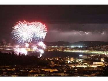 A picture taken on July 14, 2016 shows a flash of lightning as fireworks explode over the French riviera city of Nice, southeastern France, as part of France's annual Bastille Day Celebrations.