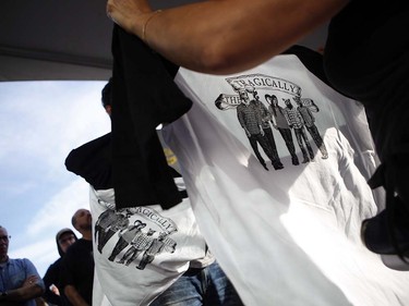 Fans buy t-shirts before the start of the Tragically Hip's Man Machine Poem Tour outside the Save-On-Foods Memorial Centre in Victoria, B.C., Friday, July 22, 2016.