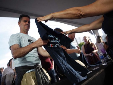 Fans buy t-shirts before the start of the Tragically Hip's Man Machine Poem Tour outside the Save-On-Foods Memorial Centre in Victoria, B.C., Friday, July 22, 2016.