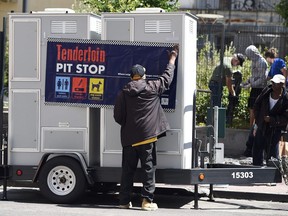 John Leggett helps to install portable toilets in the Tenderloin district of San Francisco on June 28. The Tenderloin district is commonly known as a hotbed for homelessness where people often relieve themselves on the streets. Vancouver Coun. Andrea Reimer on Monday met with housing advocates and lawyers in San Francisco to look at innovative ways to reign in uncooperative landlords who specialize in low-income housing. — Getty Images files