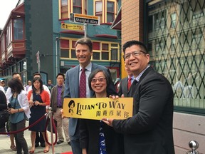 Mayor Gregor Robertson, current SUCCESS CEO Grace Wong, and Daniel To (son of Lilian To) pose with one of two newly unveiled street moniker signs that honour the late Lilian To, former SUCCESS CEO who took the immigrant outreach organization to new heights.