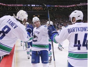 Vancouver Canuck Ben Hutton is congratulated by fellow defencemen Chris Tanev (left) and Matt Bartkowski after scoring his first career NHL goal against the New York Islanders on Jan. 17, 2016 at Brooklyn’s Barclays Center. Hutton has since teamed up with the steady Tanev as his blue-line partner.