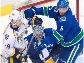 Vancouver Canucks’ defenceman Luca Sbisa (5) tries to clear Nashville Predators’ right wing Viktor Arvidsson (38) from in front of Vancouver Canucks’ goalie Ryan Miller (30) during second period NHL action in Vancouver on Saturday, March 12, 2016.