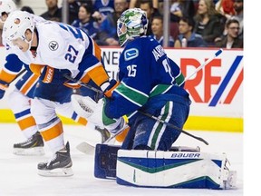 Vancouver Canucks goalie Jacob Markstrom holds on to the stick of New York Islanders #27 Anders Lee in the second period of a regular season NHL game at Rogers Arena, Vancouver March 01 2016.