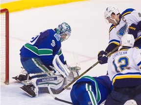 Vancouver Canucks’ goaltender Ryan Miller (30) makes a save against St. Louis Blues’ David Backes (42) during second period NHL hockey action in Vancouver on Saturday, March 19, 2016.