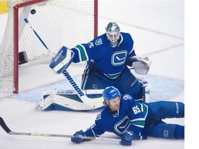 Vancouver Canucks right wing Alexandre Grenier (65) tries to stop Winnipeg Jets centre Alexander Burmistrov’s (not shown) shot from going past Vancouver Canucks goalie Jacob Markstrom (25) during second period NHL action in Vancouver on Monday, March 14, 2016.