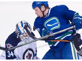 Vancouver Canucks right wing Derek Dorsett (15) tires to get a shot past Winnipeg Jets goalie Michael Hutchinson (34) during third period NHL action in Vancouver on Monday, March 14, 2016.
