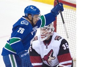 Vancouver Canucks right wing Emerson Etem (26) celebrates teammate Luca Sbisa’s goal past Arizona Coyotes goalie Louis Domingue (35) during second period NHL action in Vancouver, B.C. Wednesday, March 9, 2016.