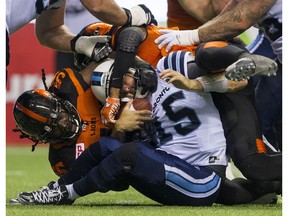 BC Lions #56 Solomon Elimimian sacks Toronto Argonauts #15 Ricky Ray as Lions #8 Bo Lokombo comes in top  during a regular season CFL football game at BC Place Vancouver, July 07 2016. The Lions were penalized on the play.