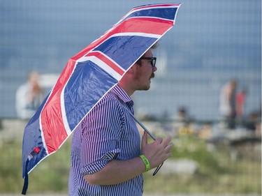 A fan uses an umbrella for sun protection at the main stage at the 39th annual Folk Music Festival at Jericho Beach,  Vancouver, July 16 2016.