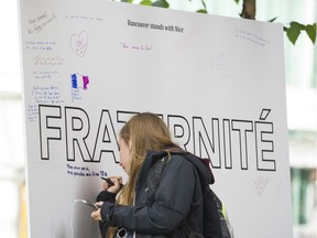 Alice Clisson dropped off a white rose and signed the messages of support board outside the French Consulate in Vancouver on Saturday, July 16.