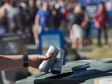 A civic-minded woman accords empty cans the respect they deserve and fits them into an recycling can to continue their odyssey to the depot at the fireworks display from team USA Disney at the Honda Celebration of Light at English Bay, Vancouver, July 30 2016.