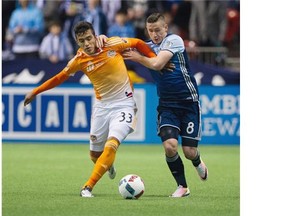 Vancouver Whitecaps FC #8 Fraser Aird and Houston Dynamo #33 Leonel Miranda battle for the ball in a regular season MLS soccer game at BC Place,  Vancouver March 26 2016.