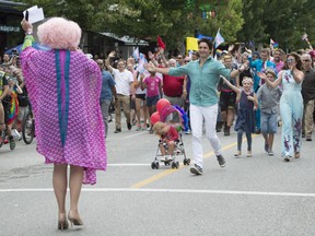 Prime Minister Justin Trudeau runs to greet a participant as his wife Sophie Gregoire Trudeau and kids Hadrien, Ella Grace and Xavier look on.