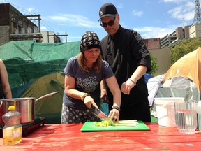 Volunteer Samona Marsh learns sanitation and basic cooking skills at the tent city protest camp on West Hastings Street under the direction of Drew Borus.