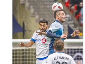 Whitecap Octavio Rivero, right, heads the ball past Montreal Impact Victor Cabrera, left  during the first half of the season opener regular season MLS match at BC Place Stadium March 6, 2016.