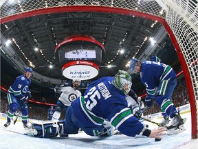 VANCOUVER, BC - MARCH 14:  Jacob Markstrom #25 of the Vancouver Canucks reaches back with his bare hand to make a save as Mathieu Perreault #85 of the Winnipeg Jets, Jake Virtanen #18 and Luca Sbisa #5 of the Vancouver Canucks watch during their NHL game at Rogers Arena March 14, 2016 in Vancouver, British Columbia, Canada.