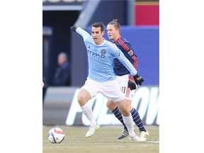 Andrew Jacobson #4 of New York City FC and Kelyn Rowe #11 of New England Revolution fight for the ball during the inaugural game of the New York City FC at Yankee Stadium on March 15, 2015 in the Bronx borough of New York City.