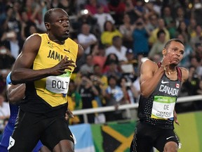 Puma partners: Jamaica's Usain Bolt (left) looks over towards Canada's Andre De Grasse as they near the finish line of the men’s 200-metre final at the Summer Olympic Games in Rio de Janeiro on Thursday. Bolt won his third straight gold medal in the event, while De Grasse captured the silver.