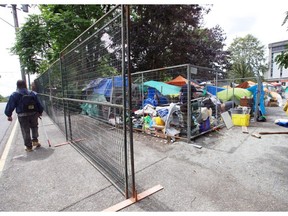 August 1, 2016 - Fences surround the tent city on the Victoria courthouse grounds on Burdett Avenue. The encampment is set to be shut down by Aug. 8. Victoria Times Colonist photo.  [PNG Merlin Archive]