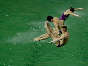 Athletes perform training dives on Wednesday at the Maria Lenk Aquatic Centre diving pool in Rio.