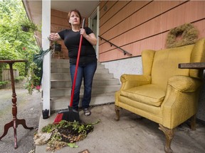 Ginger Sedlarova pauses during her cleanup of her front entrance, where a man was assaulted by four men after a road-rage incident in Burnaby.