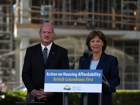 Premier Christy Clark and Finance Minister Michael de Jong, discuss amendments regarding housing issues in Greater Vancouver from the South lawn during a press conference at the Legislature in Victoria, B.C., Monday, July 25, 2016.