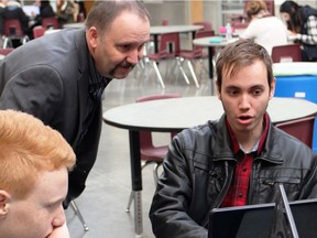 B.C. Education Minister Mike Bernier watches as students learn about computer coding at Heritage Woods Secondary in Coquitlam. His ministry is disputing a new think-tank report on education funding in B.C.