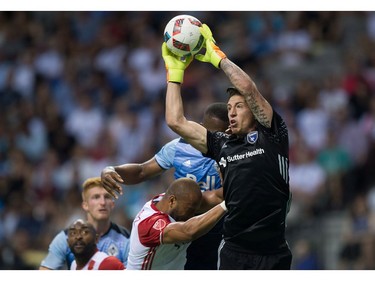 San Jose Earthquakes' goalkeeper David Bingham, right, grabs the ball out of the air as Vancouver Whitecaps' Kendall Waston, back right, attempts to get his head on it during the first half of an MLS soccer game in Vancouver, B.C., on Friday August 12, 2016.