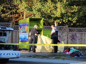 Police investigate where a man was found dead in a clothing donation bin in Surrey on Tuesday morning.