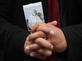 A man holds a picture of the priest Jacques Hamel outside Rouen's cathedral in France on Tuesday, during the funeral of the priest who was killed in a church in Saint-Etienne-du-Rouvray on July 26 during a hostage-taking claimed by the Islamic State group. Two 19-year-old jihadists slit Hamel's throat while he was celebrating mass.