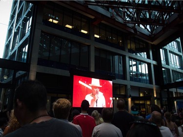 Lead singer Gord Downie is seen performing on a screen as people watch during a viewing party for the final stop in Kingston, Ont., of a 10-city national concert tour by The Tragically Hip, in Vancouver, B.C., on Saturday August 20, 2016. Downie announced earlier this year that he was diagnosed with an incurable form of brain cancer.