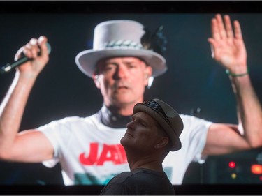 Lead singer Gord Downie is seen performing on a screen as a man watches during a viewing party for the final stop in Kingston, Ont., of a 10-city national concert tour by The Tragically Hip, in Vancouver, B.C., on Saturday August 20, 2016. Downie announced earlier this year that he was diagnosed with an incurable form of brain cancer.