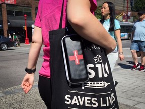 A woman carries a naloxone kit in the Downtown Eastside. Firefighters were recently given access to the drug and say they've saved lives as a result.