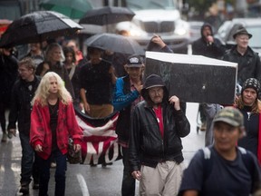 People carry a coffin to remember friends, family and community members who died as a result of overdoses, during a procession to mark Overdose Awareness Day in Vancouver's Downtown Eastside on Wednesday August 31, 2016.