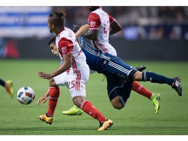 San Jose Earthquakes' Quincy Amarikwa, front left, and Vancouver Whitecaps' Matias Laba vie for the ball during the first half of an MLS soccer game in Vancouver, B.C., on Friday August 12, 2016.