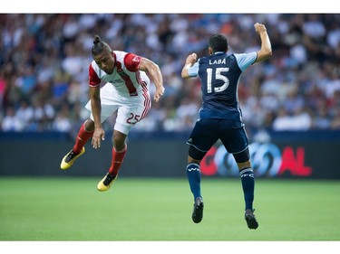 San Jose Earthquakes' Quincy Amarikwa, left, and Vancouver Whitecaps' Matias Laba vie for the ball but fail to connect as it sails over their heads during the first half of an MLS soccer game in Vancouver, B.C., on Friday August 12, 2016.