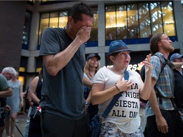 Friends, Steven Seegerts, left, and Elizabeth Robson, centre, attend a viewing party for the final stop in Kingston, Ont., of a 10-city national concert tour by The Tragically Hip, in Vancouver, B.C., on Saturday August 20, 2016. Lead singer Gord Downie announced earlier this year that he was diagnosed with an incurable form of brain cancer.